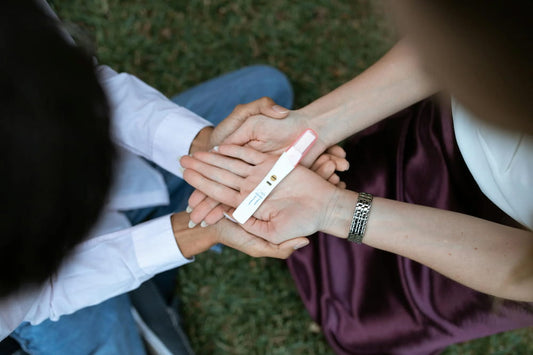 girls holding pregnancy test - lions mane benefits for females